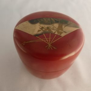 Japanese red lacquered "natsume" Edo period featuring fan design at top.