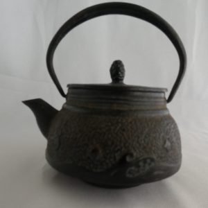 Japanese Edo period small iron tetsubin featuring waves and an acorn top pull